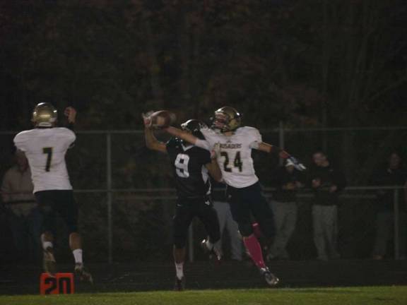 Morris Catholic's cornerback Peter Palumbo (24) reaches in to bat the ball away from Wallkill Valley's wide receiver Chirag Patel (9).
