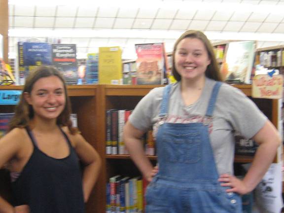 PHOTO BY JANET REDYKE Jasmine Walker (left) and Sabrina Kunze demonstrate the power they received from their love for books and the Dorothy Henry Library.