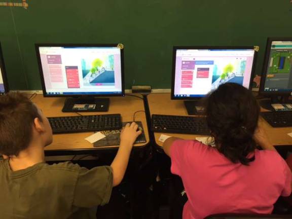 Fourth-grade students Gregory Storms and Elaina Mercado are shown coding with the characters from the movie Inside Out.