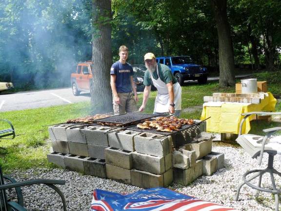 Rotary holds annual chicken BBQ Rotarian Paul Katterman is shown working the grill with his son, Zachary.