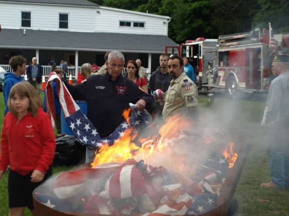 Retiring of the flag Photos by John Church Scouts line up to drop a flag into the fire.