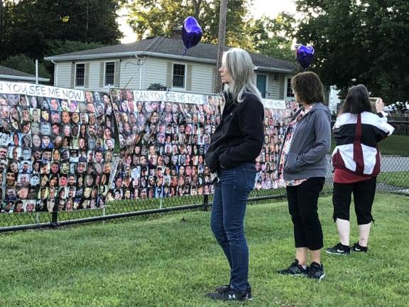 Residents look at photos of Americans who have died of drug overdoses during an event to mark International Overdose Awareness Day on Thursday, Aug. 31 at White Rock Pavilion in Jefferson. Thirty-two banners, each with 150 photos, were put together by a Facebook support group called Can You See Me Now. (Photos by Kathy Shwiff)