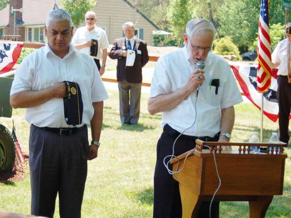 Chaplain Jay Dunham, American Legion Post 423, delivers a prayer in remembrance of the fallen members of the Military at the Post Home. Commander Mehandra Lakhicharran looks on.