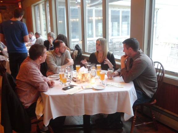 A group of patrons discusses the first food/beer pairing.