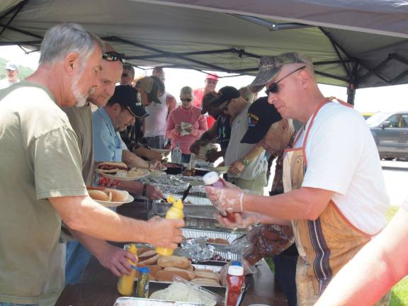 Military veterans being served food during the barbecue.
