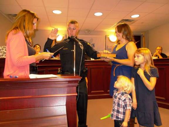 Franklin Borough Clerk Robin Hough, left, swears in new Franklin Borough police officer David Schneider on Sept. 23 while his wife and children look on.