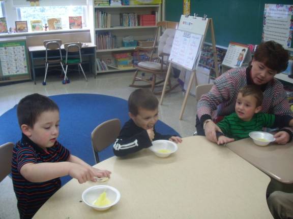 C.J. Werdann, Anthony Vacante, Drew Babcock and teacher Sharon Wylie taste the pudding.