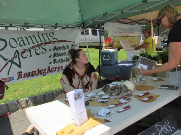 Local folks, farms and food meld together at Farmers market Roaming Acres speaks to customers.