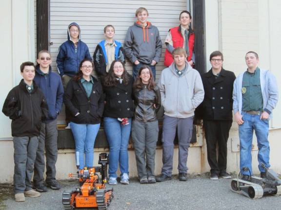 Crew photo outside EOD (Explosive Ordinance Disposal) building with bomb disposal robots.