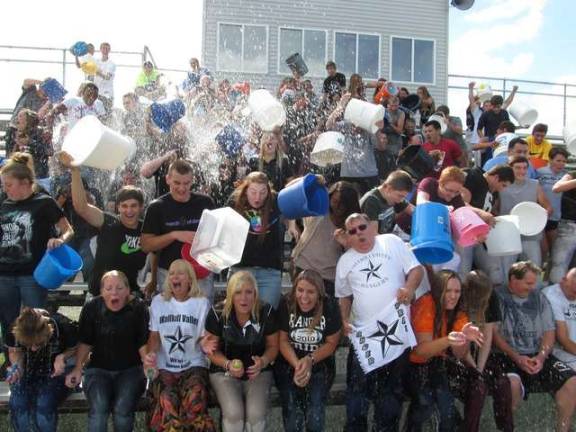 Photo by Lori Comstock Students and staff from Wallkill Valley High School Regional High School recently took the ALS Ice Bucket Challenge on Tuesday. Any student was able to come out and attend and it was held after school on the football bleachers. Interim Supertindent Robert Walker is in the middle of the photos, with the Rangers towel, white shirt, and glasses. About 100 students attended and Walker announced he was challenging Sussex Institute of Technology.