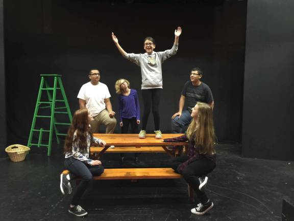 Photos provided Haley Lang (on table) as the Cook prepares to tell the next tale as (from left to right) Olivia Weintraub, Terrell Cannon, Annalyse Svendsen, Alejandro De Los Santos and Hannah Billing look on.)