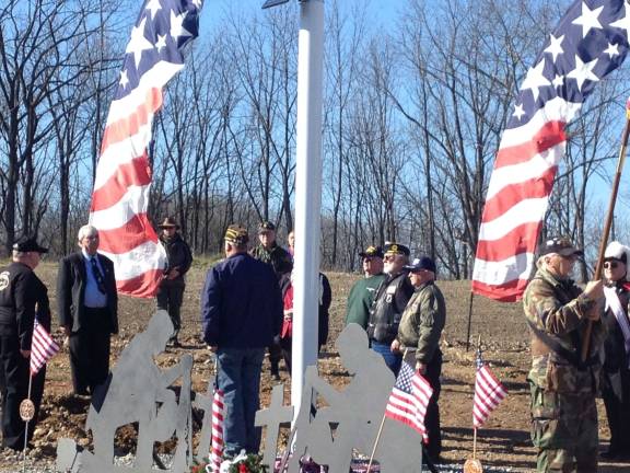 PHoto by Gary Band John Harrigan and others look on as the ashes from incinerated American flags are buried at the new Northern New Jersey Veterans Memorial Cemetery.