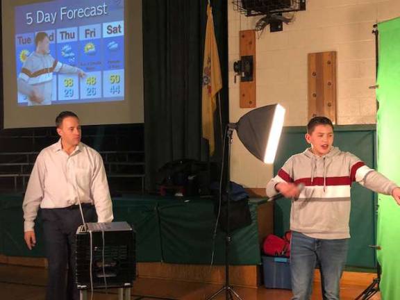 PHOTOS BY LAURA J. MARCHESE John Marshall, left, watches as an Ogdensburg student does the weather.
