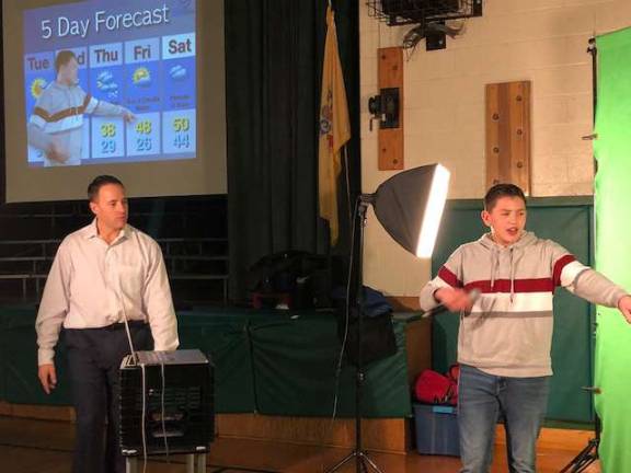 PHOTOS BY LAURA J. MARCHESE John Marshall, left, watches as an Ogdensburg student does the weather.