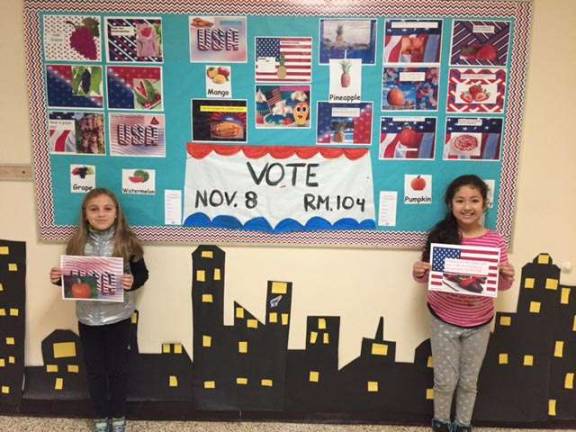 Students standing in front of the campaign board made by the third grade class. Gabrielle Cox and Valeria Gonzalez are pictured.