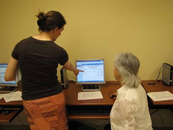 Project Self-Sufficiency staff member Cora Chandler demonstrates proper computing techniques to a participant in the agency&#x2019;s Higher Opportunities for Women program.