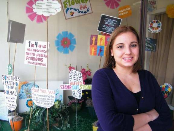 Volunteer Nicole Helewa is shown at the entrance display at Family Partners in Newton. Helewa completed the display using flower pots this past April