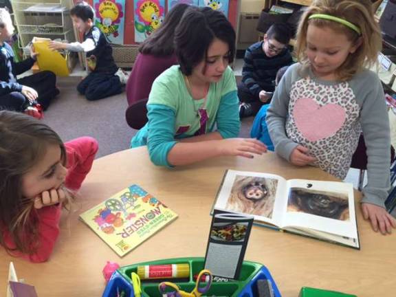 Mrs. Mongon's fifth-grade classe visited the first-grade classrooms to read their descriptive Native American travel brochures with their reading buddies. The first-graders also shared their books with the fifth-graders to meet the &quot;reading to a younger child&quot; act of kindness.
