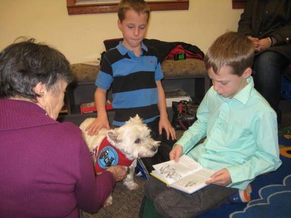 Charles and Vaughan Holderith practice reading with an interested Mazie.