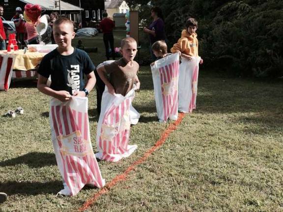 Kids participate in a sack race.