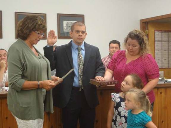 PHOTOS BY SCOTT BAKER New Hamburg police officer Lawrence Barcza is sworn in by Borough Clerk Doreen Schott during Monday's council meeting. His family is at right.