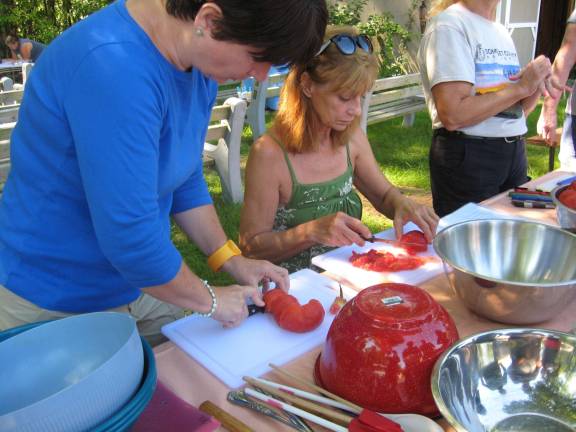 Lorraine Achrem, sitting, and Jeannie Kline, left, are shown cutting tomatoes to make salsa.