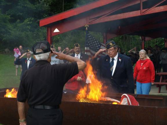 Retiring of the flag Legion members salute as the first flag burns.