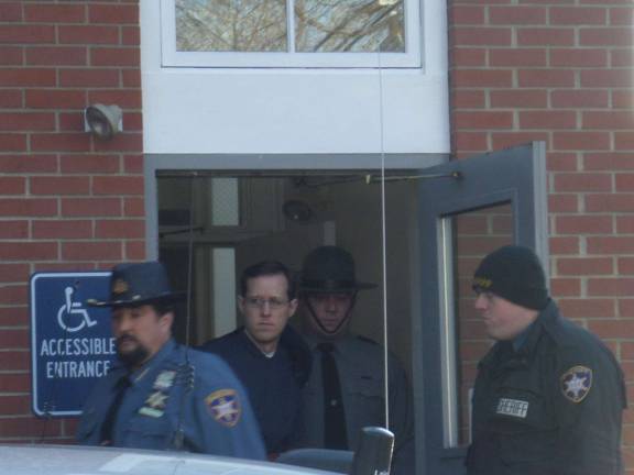 Eric Frein is escorted out of Pike County Court in Milford earlier this month after a preliminary hearing where he was ordered to stand trial in the shootings of two state troopers. Frein pleaded not guilty on Thursday via video link from Pike County Correctional Facility. Photo by Nathan Mayberg