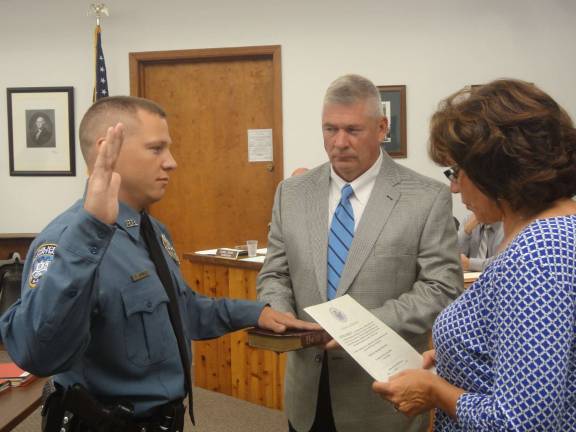 Hamburg swears in two new police officers Patrolman Devin Gormley takes the Oath of Office while his father, Charlie Gormley, holds the Bible on Monday in Hamburg. Photo by Scott Baker