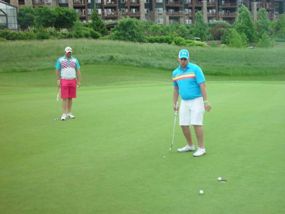 The winning putt is holed by Joe Shields as his partner Mike Clohessy looks on.
