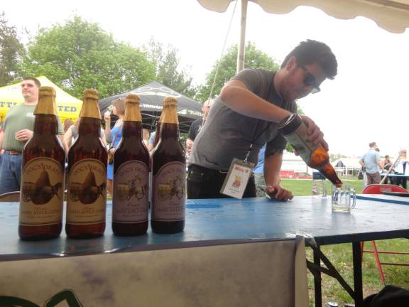 Photos by Scott Baker Mike Moran, of the Warwick Valley Winery, pours samples of several varieties of Doc's Hard Cider.