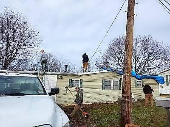 Neighbors, community come together to help woman Volunteers from Fairview Lake YMCA help repair the roof. (Photos provided by Liz Pattermann)