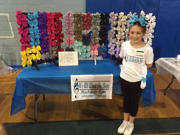 Fourth-grade business owner, Mackenzie Lynn, selling her handmade bows.