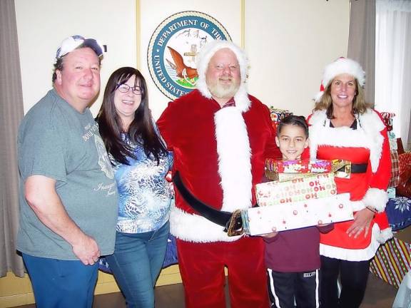 Santa Collins with Andy Lagana, Jamie Novoshelski, happy gift recipient Jakob Velasco and Loraine Collins