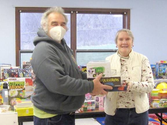Toy drive organizer Bob Winter helps volunteer Dawn Schofer organize the donations (Photo by Janet Redyke)