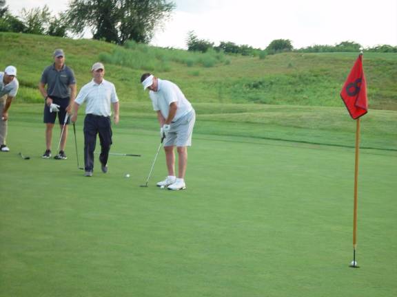 Member of the Team Sylvester sinks a 50-foot putt to save a bogey on the 8th hole at Ballyowen Golf Club