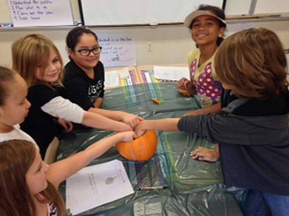 Angela Patti, Rebecca Fedder, Mariah Lee, Emma Finamore, Janiesha Dureny, Jackson Moller reach into a pumpkin.