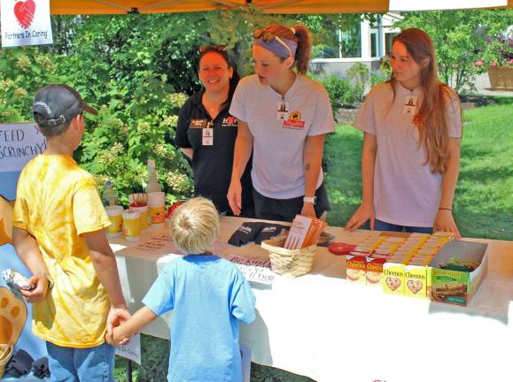 Patty Gates (Flanders), Brandie Ellis (Long Valley), and Melissa Boffa (Sparta) give out goodies and prizes to young customers who donate to the ShopRite Partners in Caring campaign.