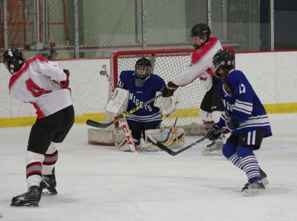 High Point-Wallkill Valley's Tucker Eckert (4) blasts the puck towards the goal post.