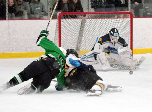 Sparta-Jefferson's goalkeeper Logan Hanek drops down in an attempt to intercept the puck as fellow hockey players collide on the ice in the second period. Hanek stopped 16 shots. Sparta Jefferson United defeated Kinnelon High School (Morris County, N.J.) in varsity ice hockey on Saturday, November 25, 2017. The final score was 5-2. The season opening game took place at Skylands Ice World in Stockholm, New Jersey.