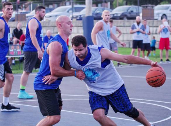 Team Smalley's captain John Smalley moves the ball forward while covered by Team Tobin's, Mike Tobin.