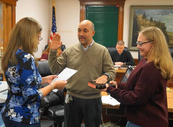 From left, Borough Clerk Robin Hough administers the Oath of Office to Councilman David Astor, with Charlotte Gough holding the Bible.