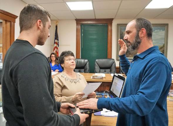 On right, Councilman Anthony Nasisi repeats the oath of office. From left, John Nasisi holds the Bible and Borough Clerk Phyllis Drouin administers oath.