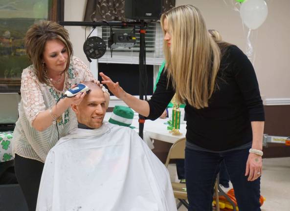 PHOTOS BY VERA OLINSKI Two volunteers shave the head of county Freeholder Jonathan Rose.