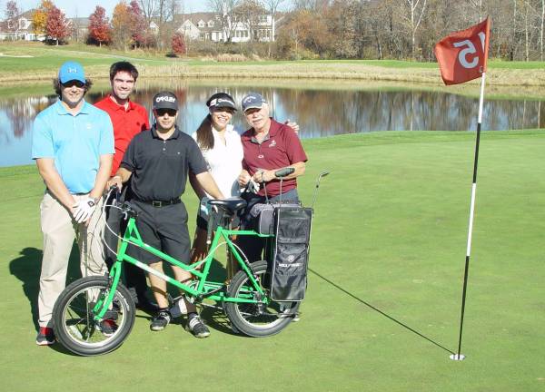 The Cascades Golf Course Team of Brett Hill, Kim Lyons, George Schneider and Brendan Rowen pose on the 15th green with Eric Wefer after completing their golf bicycle relay race.