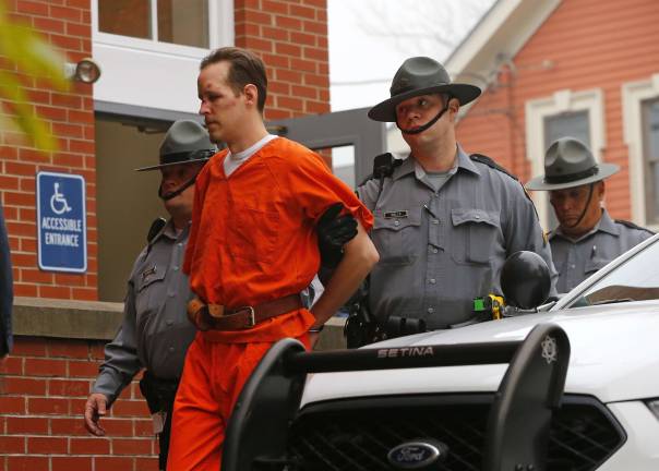 Eric Frein is escorted by police into the Pike County Courthouse for his arraignment in Milford, Pa., Friday Oct. 31, 2014. Frein, was captured seven weeks after police say he killed a Pennsylvania State trooper in an ambush outside a barracks in northeastern Pennsylvania. (AP Photo/Rich Schultz)