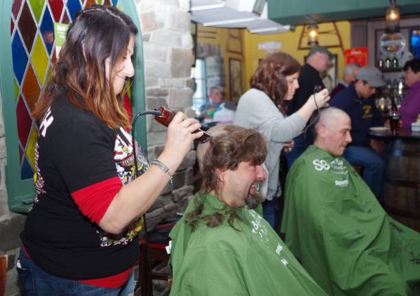 Close cuts for kids with cancer Darrin Jaworski of Hamburg kept his cool as Stacy Dolan of Franklin's Rumours II shaved his head.