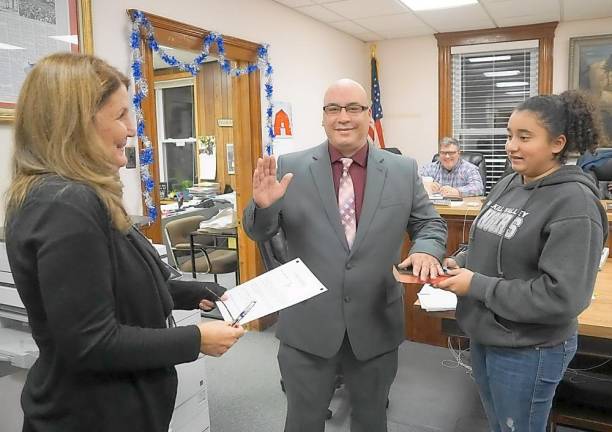 From left, Borough Clerk Robin Hough administers the Oath of Office to Councilman John Cruz, with Aryanna Cruz on right.