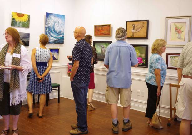 Art patrons attending the opening reception for the &#xfe;&#xc4;&#xfa;A Thing of Beauty&#xfe;&#xc4;&#xf9; show at the Skylands Gallery &amp; Studio take a closer look at the interesting and diverse artwork.