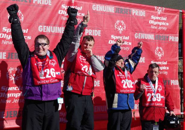 Four athletes proudly acknowledge the crowd after being awarded a variety of medals at the 2016 Special Olympics Winter Games held Tuesday at Mountain Creek.